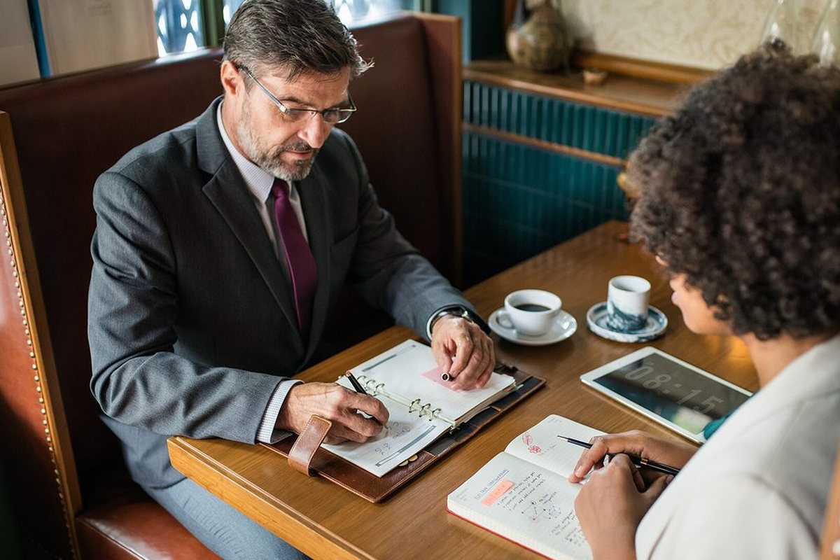 Two people working through written notes together at a table